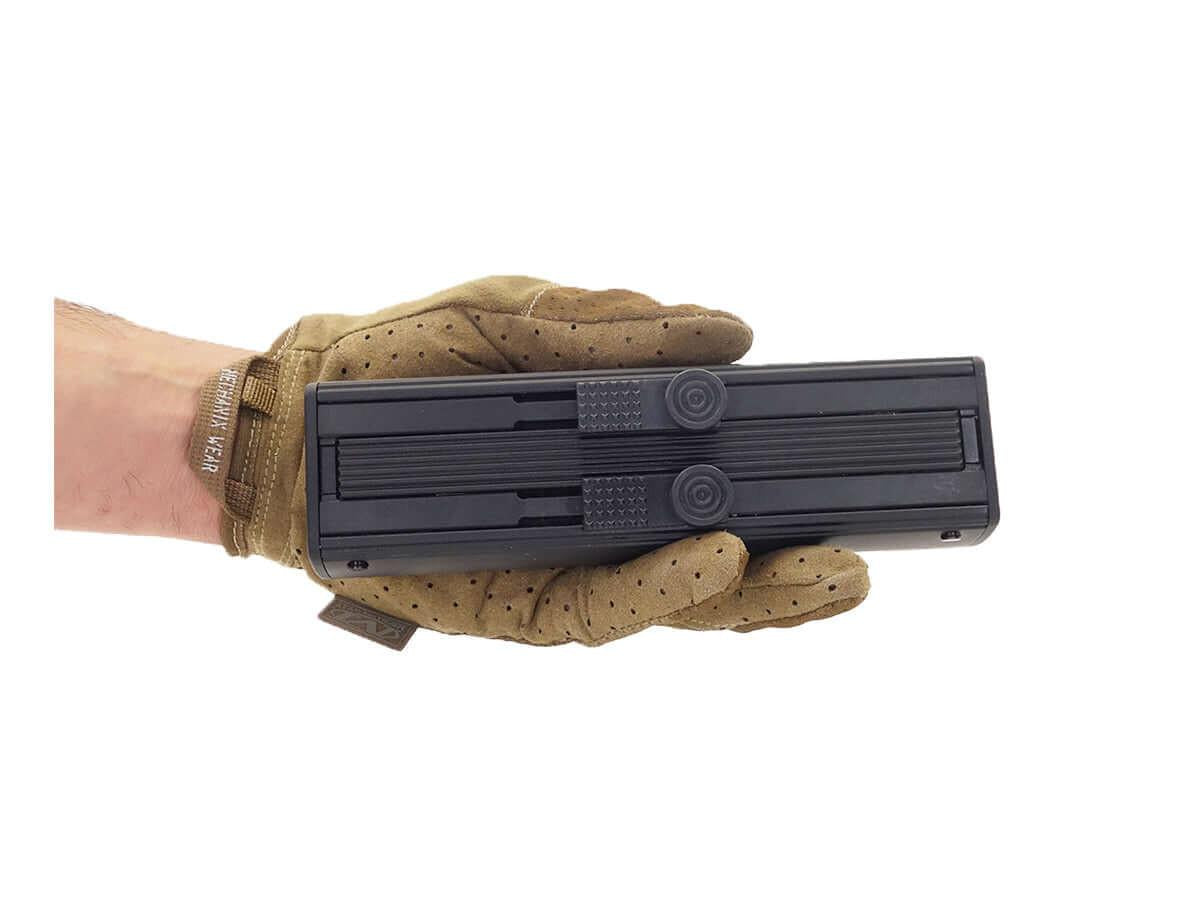 Main tenant un accessoire de défense noir TS68 CO2 avec gants tactiques marron
