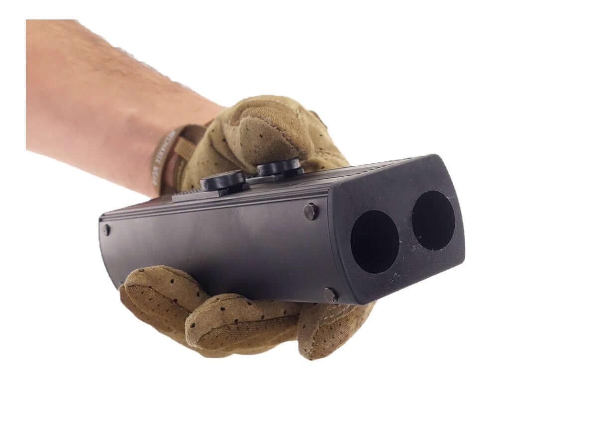 Pistolet de défense CO2 calibre 68 noir à deux canons tenu en main avec gant tactique